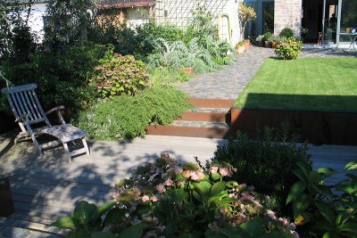 Garten mit Holzterrasse und Natursteinweg